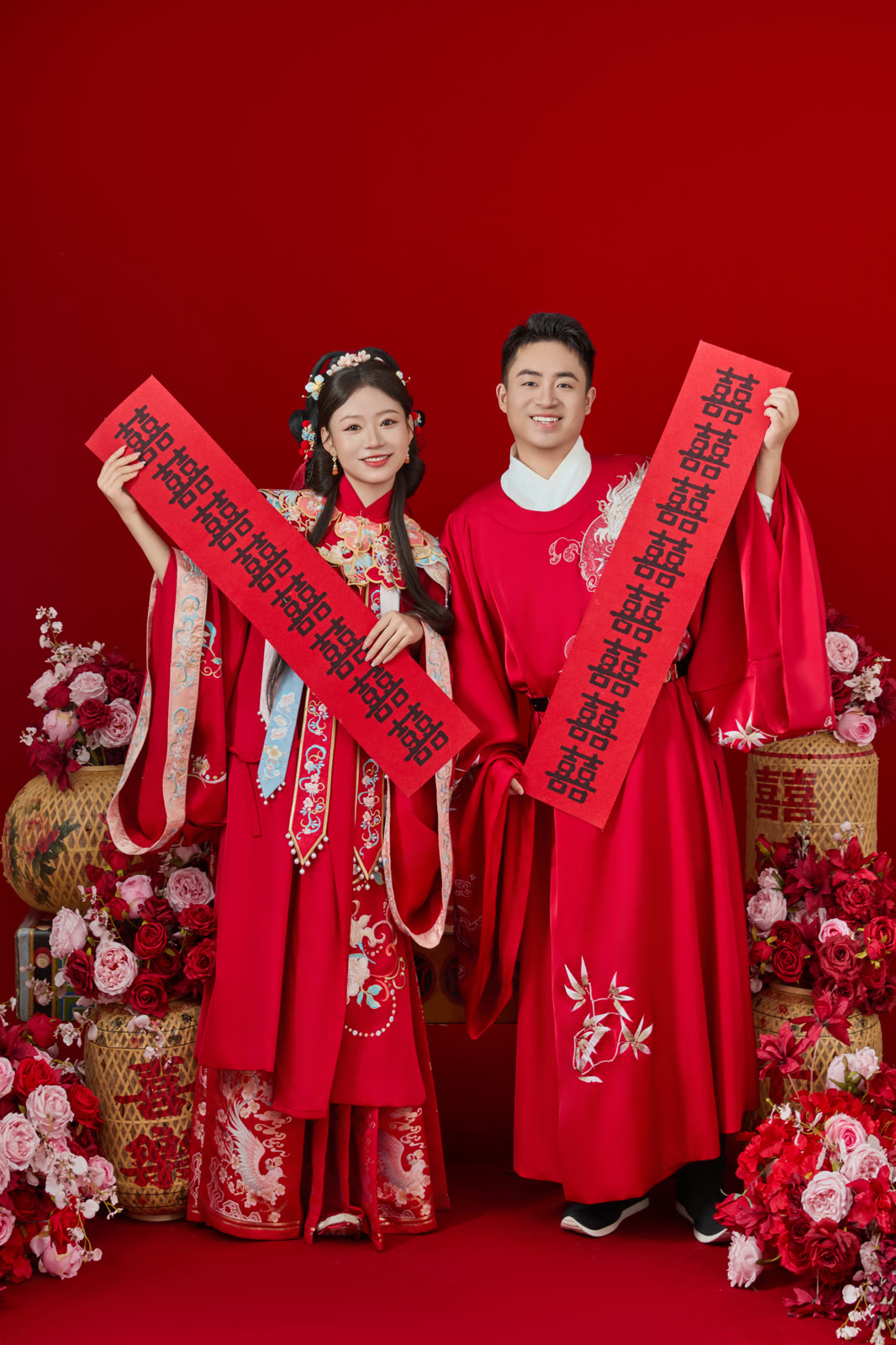 钱立勇与王若昕身着红色中式礼服，手持喜字